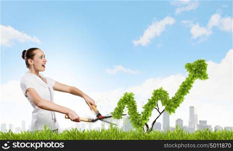 Woman cutting bush. Young happy businesswoman cutting bush shaped like graph. Growth concept
