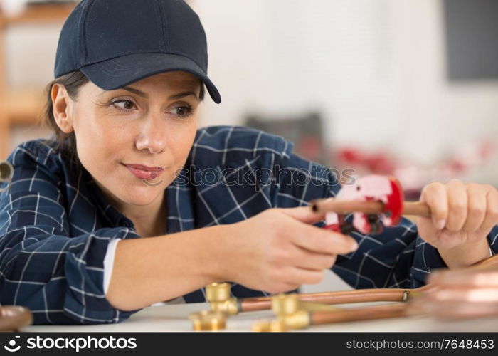 woman cutting cooper pipes