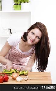 woman cutting paprika. young woman in kitchen cutting green paprika
