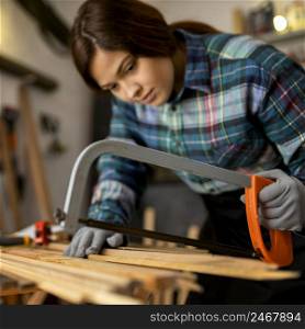 woman cutting wood planks