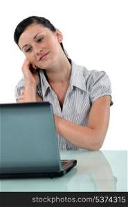 Woman daydreaming in front of her laptop