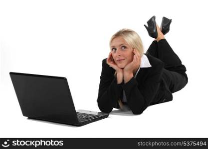 Woman daydreaming in front of her laptop