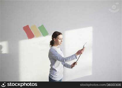 Woman deciding on paint sample in new apartment