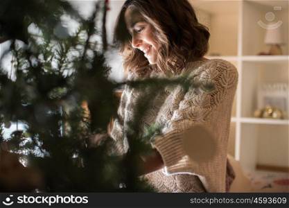 Woman decorating Christmas Tree at home - Winter Season