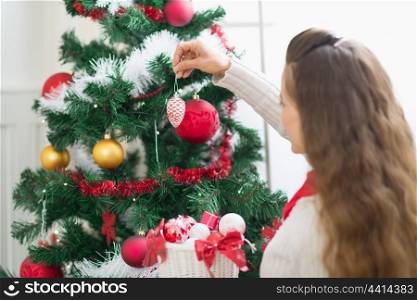 Woman decorating Christmas tree. Rear view