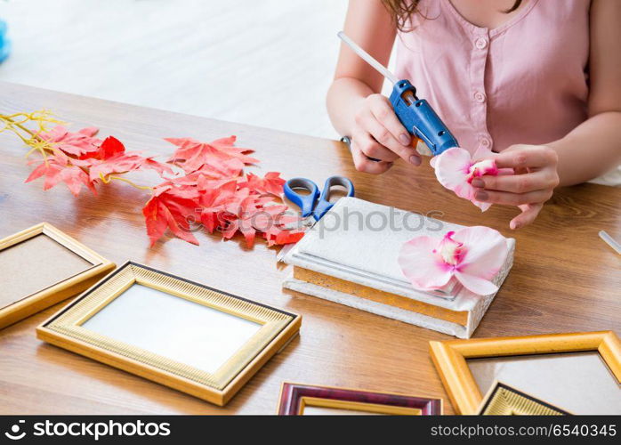 Woman decorating picture frame in scrapbooking concept