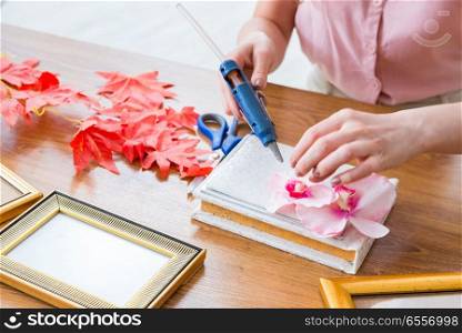 Woman decorating picture frame in scrapbooking concept