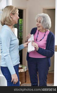 Woman Delivering Newspaper To Elderly Neighbour