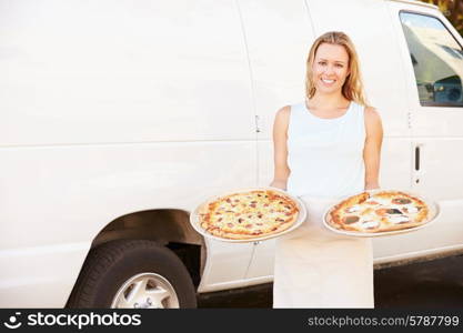 Woman Delivering Pizza Standing In Front Of Van