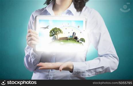 Woman demonstrating green life concept. Young woman presenting perfect ecology model with help of tablet pc