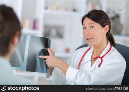 woman dentist and her female patient looking at x-ray image