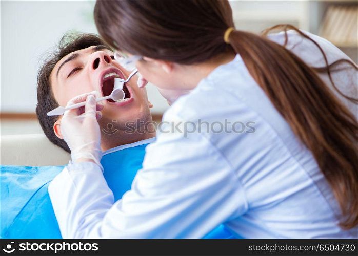 Woman dentist doctor with male patient in hospital
