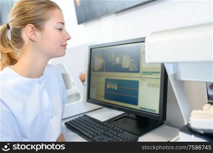 woman dentist looking at screen with patients x-ray