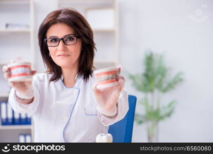 Woman dentist working on teeth implant