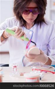 Woman dentist working on teeth implant