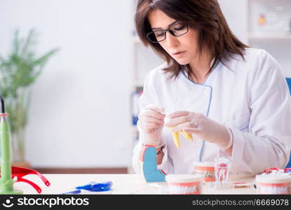 Woman dentist working on teeth implant