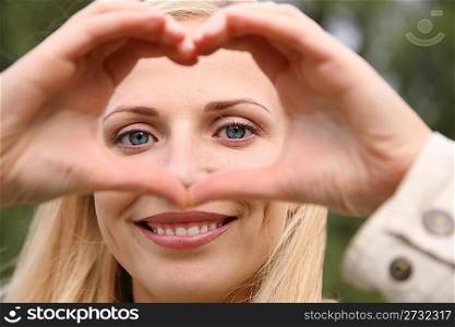 woman depicts the heart as hands