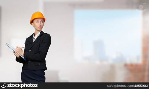 Woman designer in interior. Attractive elegant woman in helmet in modern interior. Mixed media