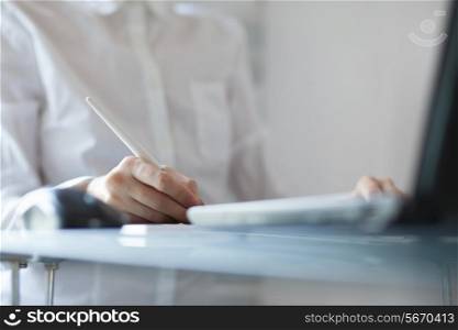 Woman designer using a graphics pad with notebook