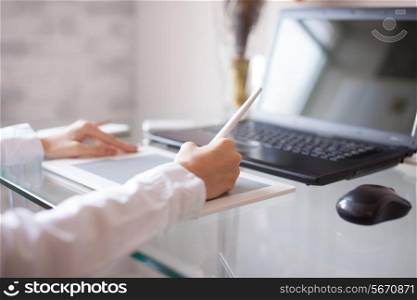 Woman designer using a graphics pad with notebook