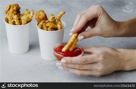woman dipping chips ketchup