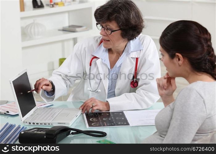 Woman discussing her pregnancy with a doctor