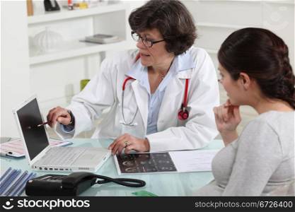 Woman discussing her pregnancy with a doctor