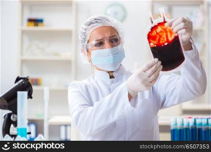 Woman doctor checking blood samples in lab