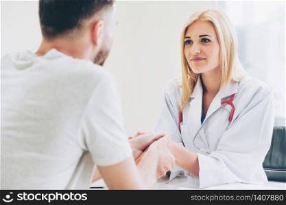Woman doctor doing handshake with male patient in hospital office room. Healthcare and medical service occupation.. Woman Doctor and Male Patient in Hospital Office