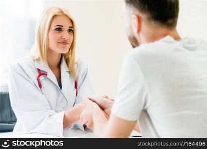 Woman doctor doing handshake with male patient in hospital office room. Healthcare and medical service occupation.. Woman Doctor and Male Patient in Hospital Office