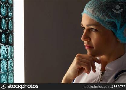 Woman doctor examining x-ray. Image of attractive woman doctor looking at x-ray results