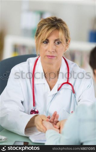woman doctor holding the hand of a patient