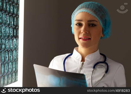 Woman doctor holding x-ray. Image of attractive woman doctor holding x-ray results