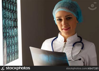 Woman doctor holding x-ray. Image of attractive woman doctor holding x-ray results