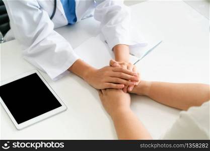 Woman doctor holds patient hand patient in room of hospital office. Healthcare and medical service.