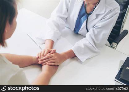 Woman doctor holds patient hand patient in room of hospital office. Healthcare and medical service.. Woman Doctor and Female Patient in Hospital Office