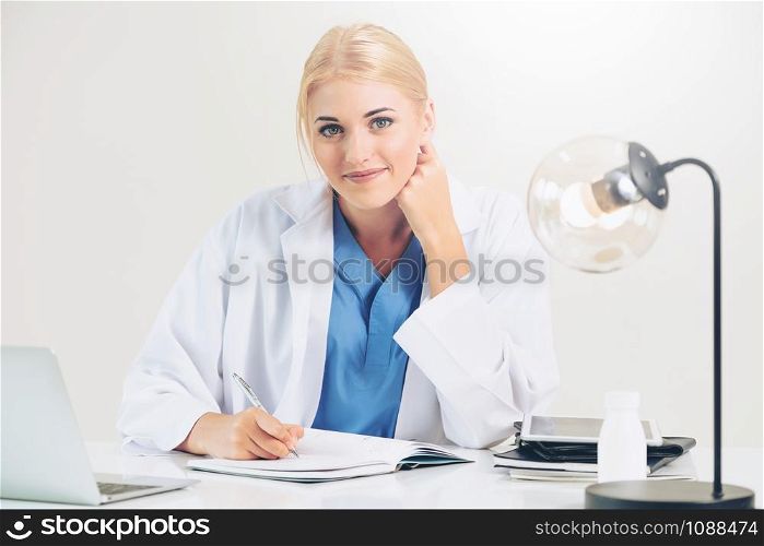 Woman doctor in hospital or healthcare institute working on medical report at office table.