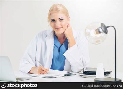 Woman doctor in hospital or healthcare institute working on medical report at office table.
