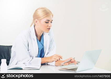 Woman doctor in hospital or healthcare institute working on medical report at office table.. Doctor in hospital working on medical report.