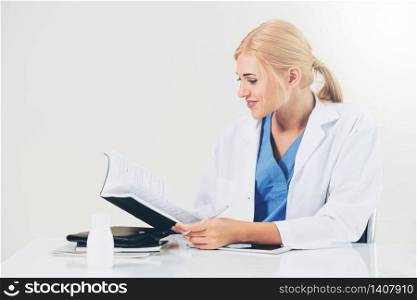 Woman doctor in hospital or healthcare institute working on medical report at office table.. Doctor in hospital working on medical report.