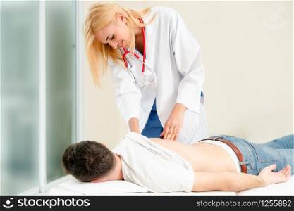 Woman doctor is examining male patient in hospital office. Healthcare and medical service.