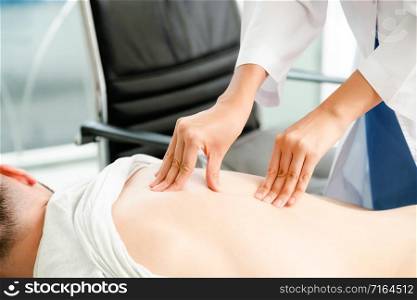 Woman doctor is examining male patient in hospital office. Healthcare and medical service.. Woman Doctor and Male Patient in Hospital Office