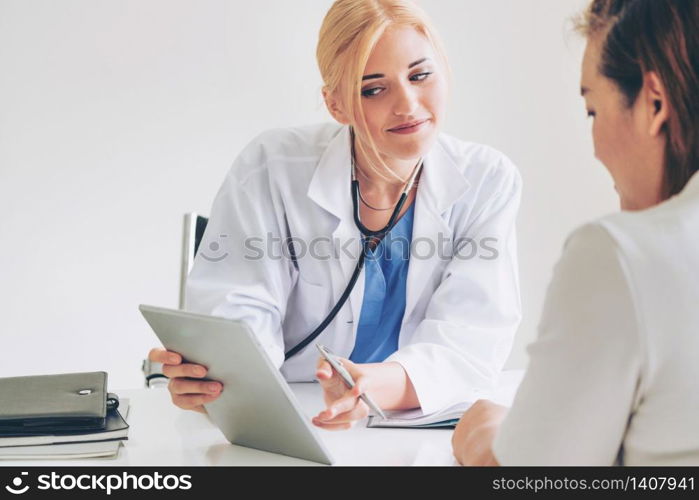 Woman doctor is talking and examining female patient in hospital office. Healthcare and medical service.. Woman Doctor and Female Patient in Hospital Office