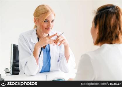 Woman doctor is talking and examining female patient in hospital office. Healthcare and medical service.. Woman Doctor and Female Patient in Hospital Office