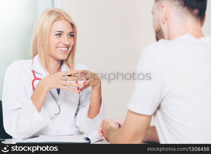 Woman doctor is talking to male patient in hospital office. Healthcare and medical service.. Woman Doctor and Male Patient in Hospital Office