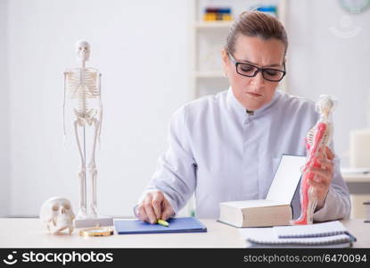 Woman doctor studying human skeleton