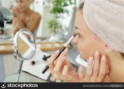 woman does her make up after shower