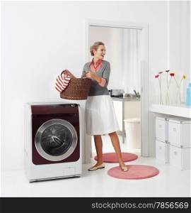 woman doing a housework holding basket of laundry