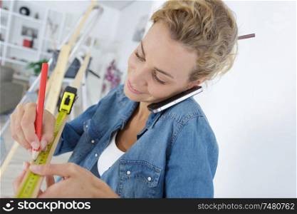 woman doing diy while talking on the phone