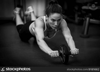 Woman Doing Exercise with Abs Roller Wheel in The Gym, black and white